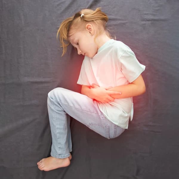 Child holding their stomach in pain